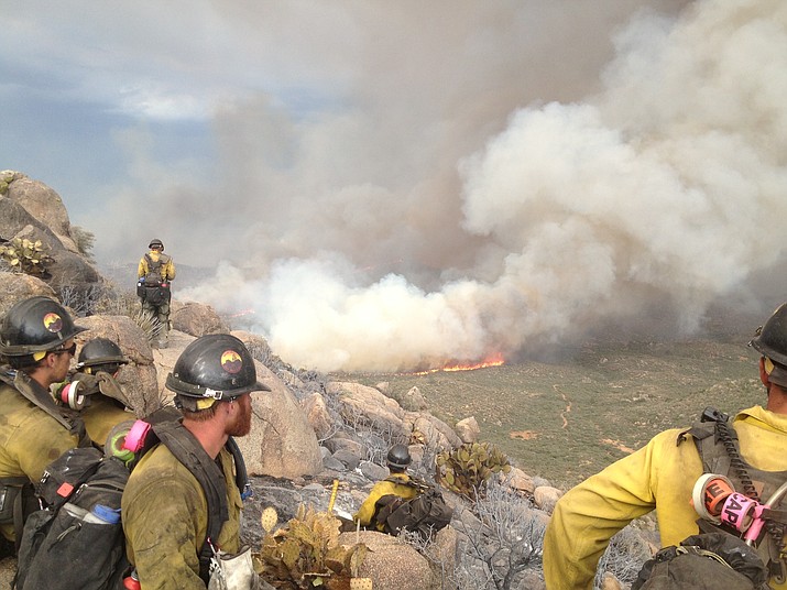 The Granite Mountain Hotshots watch the Yarnell Hill Fire from a burned-out area on June 30, 2013, less than an hour before the wildfire blocked their escape through a valley and overran their position, killing them. (Hotshot Christopher MacKenzie/Courtesy of his family)