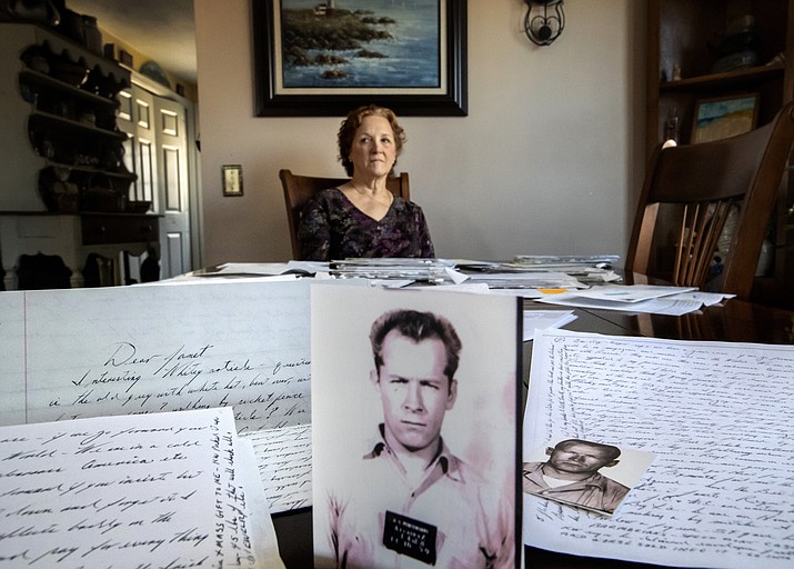 Janet Uhlar sits for a photo at her dining room table with an arrangement of letters and pictures she received through her correspondence with imprisoned Boston organized crime boss James "Whitey" Bulger, Friday, Jan. 31, 2020, in Eastham, Mass. Uhlar was one of 12 jurors who found Bulger guilty in a massive racketeering case, including involvement in 11 murders. But now she says she regrets voting to convict Bulger on the murder charges, because she learned he was an unwitting participant in a secret CIA experiment in which he was dosed with LSD on a regular basis for 15 months. (David Goldman/AP)