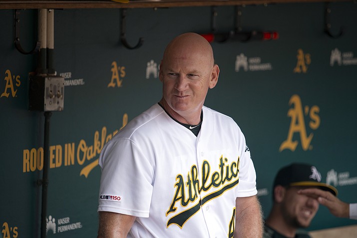 FILE - In this Sept. 22, 2019, file photo, Oakland Athletics third base coach Matt Williams is shown in the dugout before a baseball game against the Texas Rangers in Oakland, Calif. Back managing a team, just being able to talk with his players is a challenge for Matt Williams. About 10 miles from the spring training camps of the Boston Red Sox and Minnesota Twins, the 54-year-old is at spring training with South Korea's Kia Tigers.“You never know whether you’re going to get another chance to manager or not, so I look at it as a challenge or an opportunity,’’ he said, sitting in some small metal bleachers. “So far it’s been a lot of fun.” (AP Photo/D. Ross Cameron, File)