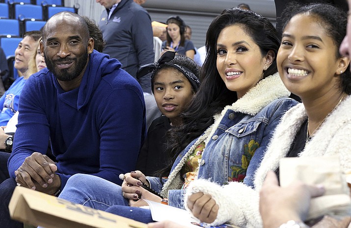 FILE - In this Nov. 21, 2017 file photo, from left, Los Angeles Lakers legend Kobe Bryant, his daughter Gianna Maria-Onore Bryant, wife Vanessa and daughter Natalia Diamante Bryant are seen before a Connecticut-UCLA NCAA women's basketball game in Los Angeles. Kobe Bryant's widow on Monday, Feb. 24, 2020, sued the owner of the helicopter that crashed in fog and killed the former Los Angeles Lakers star and their 13-year-old daughter Gianna last month. The wrongful death lawsuit filed by Vanessa Bryant in Los Angeles Superior Court said the pilot was careless and negligent by flying in cloudy conditions Jan. 26 and should have aborted the flight. (AP Photo/Reed Saxon, File)