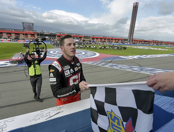 Alex Bowman accepts the checkered flag from an official after winning a NASCAR Cup Series auto race Sunday, March 1, 2020 in Fontana, Calif. (Will Lester/AP)