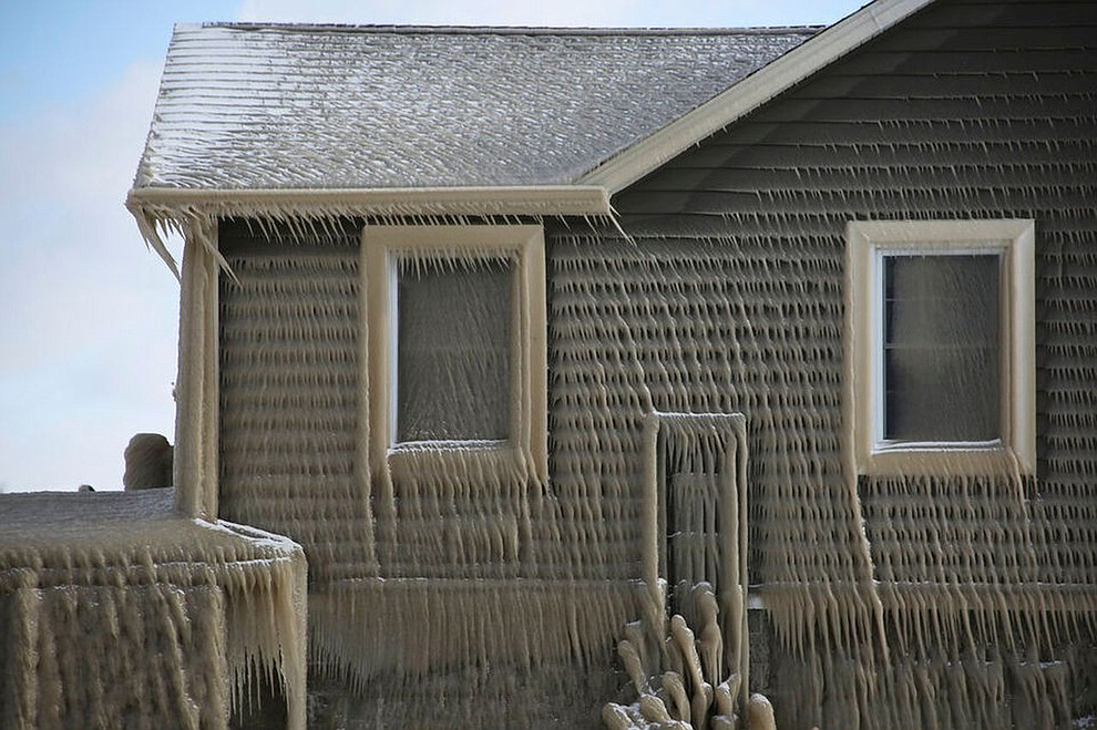 Houses along Hoover Beach are covered by ice from high winds and 15-foot Lake Erie waves, Saturday, Feb. 29, 2020, in Hamburg N.Y. (AP Photo/Jeffrey T. Barnes)