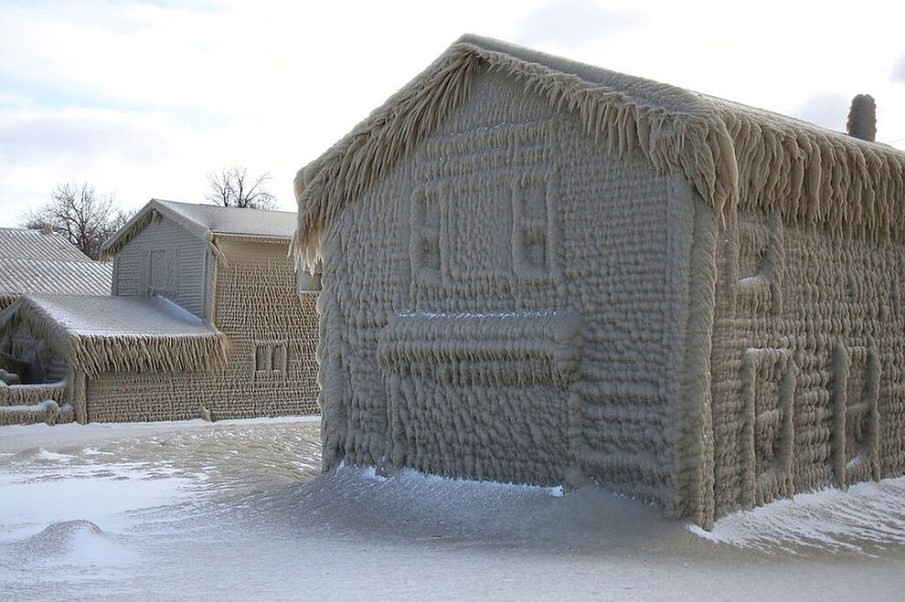 Houses along Hoover Beach are covered by ice from high winds and 15-foot Lake Erie waves, Saturday, Feb. 29, 2020, in Hamburg N.Y. (AP Photo/Jeffrey T. Barnes)