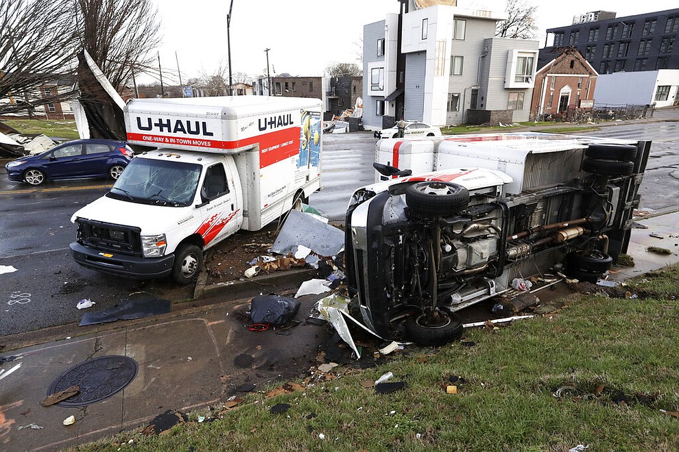 Damaged trucks sit on a sidewalk as well as the street following a deadly tornado, Tuesday, March 3, 2020, in Nashville, Tenn. Tornadoes ripped across Tennessee early Tuesday, shredding buildings and killing multiple people. (AP Photo/Mark Humphrey)