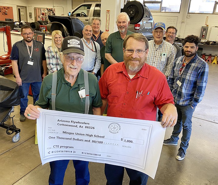 Arizona Flywheelers President Gary Covert, left, recently presented $1,000 to Mingus Union High School for its career and technical education programs – known as CTE. Accepting the check, Andy Hooton, Mingus Union auto instructor. Also pictured, from left, Mingus Union’s Eric Banuelos, Rynnie Scott, Jeff Neugebauer and Rick Finney, Arizona Flywheelers members Jack Castimore, Steve Rench and Kelly Somers, and Mingus Union’s Steve Kuntz and Michael Garcia. VVN/Bill Helm