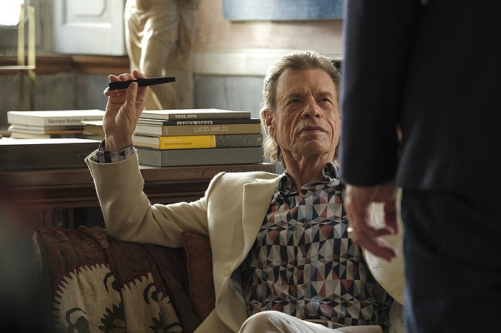 This image released by Sony Pictures Classics shows Mick Jagger in a scene from the film, "The Burnt Orange Heresy." Jagger plays a devilish art collector who cunningly convinces an art journalist to use a rare interview with a reclusive artist as an opportunity to steal one of his paintings. It’s Jagger’s first film since 2001’s “The Man From Elysian Fields.” (Jose Haro/Sony Pictures Classics via AP)