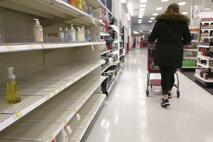 In this March 3, 2020 file photo, shelves that held hand sanitizer and hand soap are mostly empty at a Target in Jersey City, N.J. People who may have been exposed to the new coronavirus or who get sick with COVID-19 may be advised to stay home for as long as 14 days to keep from spreading it to others, according to the Centers for Disease Control. That’s led many people to wonder if they could manage for two weeks at home without a run to the grocery store. (AP Photo/Seth Wenig)
