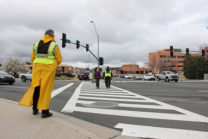 Yavapai Regional Medical Center security personnel assist hospital staff across the street at the intersection of Iron Springs Road/Whipple Street and Willow Creek/Miller Valley roads Thursday, March 12, 2020. At the corner of Iron Springs Road and Willow Creek Road is an off-duty Prescott Police Department officer assisting to patrol the busy intersection. The intersection’s crosswalks were recently restriped as well to enhance pedestrian safety. (Max Efrein/Courier)