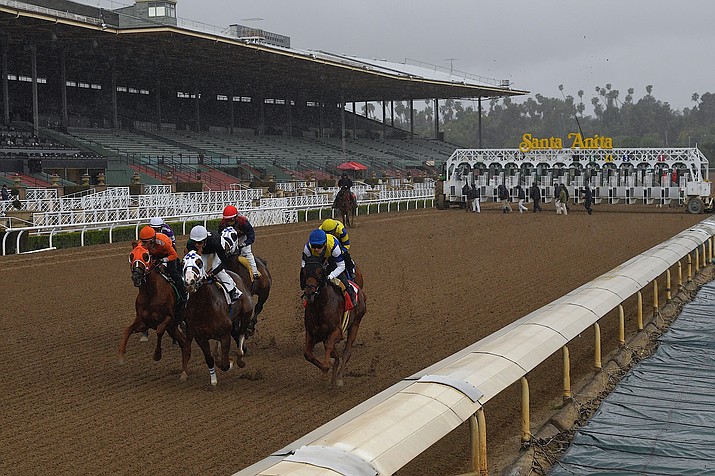 Horses run in the fourth race at Santa Anita Park in front of empty stands, Saturday, March 14, 2020, in Arcadia, Calif. While most of the sports world is idled by the coronavirus pandemic, horse racing runs on. (Mark J. Terrill/AP)