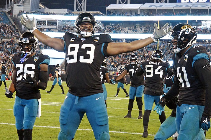 In this Sunday, Dec. 29, 2019, file photo, Jacksonville Jaguars defensive end Calais Campbell (93) celebrates his touchdown against the Indianapolis Colts on a fumble recovery with safety Jarrod Wilson (26) and linebacker Josh Allen (41) during the second half of an NFL football game, in Jacksonville, Fla. On Sunday, March 15, 2020, the Baltimore Ravens agreed to trade a fifth-round draft pick in the upcoming draft to the Jacksonville Jaguars for veteran defensive lineman Calais Campbell. (Stephen B. Morton, AP File)