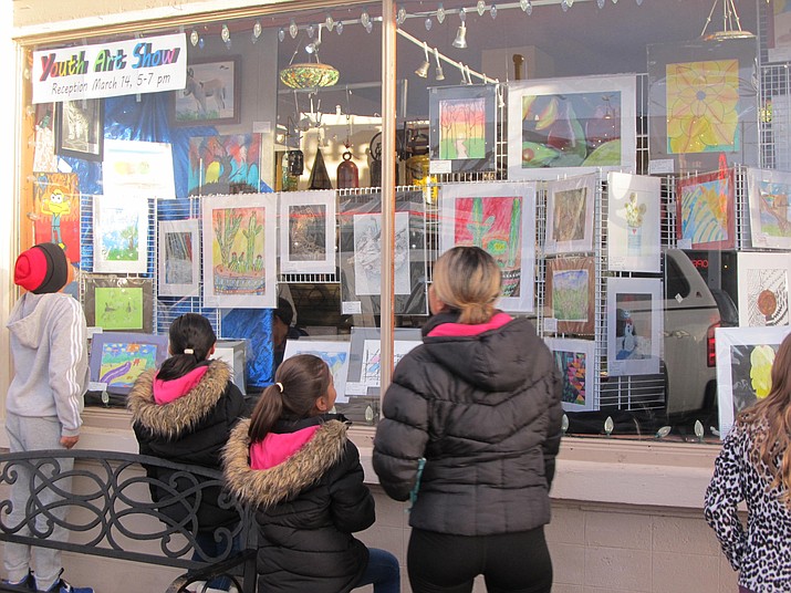 The Lara family admires the store front display at The Gallery in Williams celebrating Youth Art Month. (B. Garibay/WGCN)