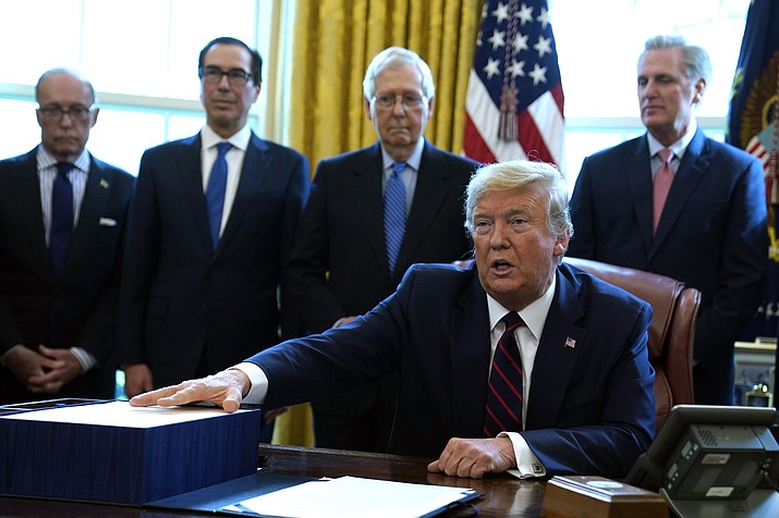 President Donald Trump speaks before he signs the coronavirus stimulus relief package in the Oval Office at the White House, Friday, March 27, 2020, in Washington. Listening are from left, Larry Kudlow, White House chief economic adviser, Treasury Secretary Steven Mnuchin, Senate Majority Leader Mitch McConnell, R-Ky., and House Minority Leader Kevin McCarty of Calif. (Evan Vucci/AP)