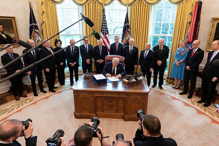 President Donald Trump signs the Coronavirus Aid, Relief, and Economic Security – CARES – Act just hours after it was rushed through the House Friday. The $2.2 trillion economic stimulus package includes funds for businesses and individuals affected by the fallout from COVID-19. (Photo by Shealah Craighead/The White House)