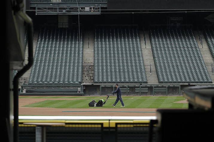 A grounds crew worker cuts the infield in front of empty seats at T-Mobile Park in Seattle, Thursday, March 26, 2020, around the time when the first pitch would have been thrown in the Mariners' Opening Day baseball game against the visiting Texas Rangers. Earlier in the month, Major League Baseball called off the start of the season due to the outbreak of the new coronavirus. (Ted S. Warren/AP)