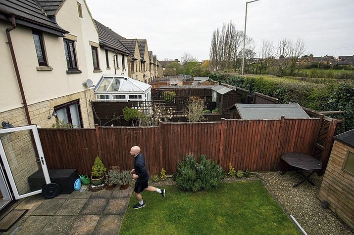 James Campbell runs a charity marathon to raise funds for the NHS, in his garden, while the country is in lockdown to control the spread of coronavirus, in Cheltenham, England, Wednesday April 1, 2020. The former international athlete is spending his birthday running - in his seven-metre-long back garden - and will take over 7,000 shuttles back and forth to finish the 26.2-mile marathon. (Jacob King/PA via AP)