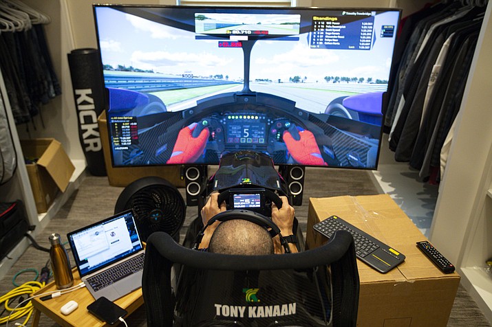 In this March 28, 2020, file photo, IndyCar driver Tony Kanaan, of Brazil, uses a racing simulator in his home in Indianapolis to practice for a virtual racing event. As Robert Wickens fought his way back from a spinal cord injury, he kept dreaming about the day he could run against his old racing buddies. The promising Canadian driver believes he'll take his biggest step yet by making his debut in the IndyCar iRacing Challenge — a virtual race being held Saturday, April 4, 2020, on the Barber Motorsports Track in Alabama. (Michael Conroy/AP, file)