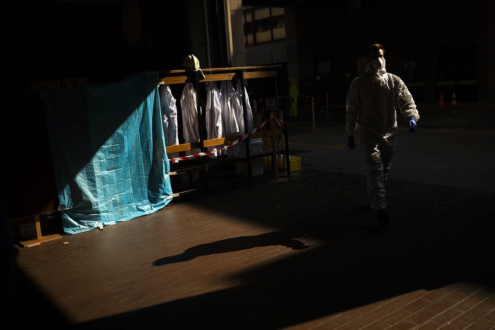 A firefighter, wearing full protective equipment, leaves to pick up a coronavirus patient in Brussels, Thursday, April 9, 2020. The new coronavirus causes mild or moderate symptoms for most people, but for some, especially older adults and people with existing health problems, it can cause more severe illness or death. (AP Photo/Francisco Seco)