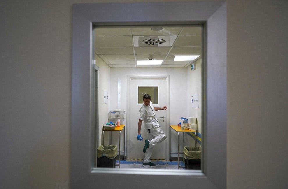 A doctor disinfects his shoes as he leaves the ICU unit of Rome's San Filippo Neri Hospital's Covid department, in Rome, Thursday, April 9, 2020. The new coronavirus causes mild or moderate symptoms for most people, but for some, especially older adults and people with existing health problems, it can cause more severe illness or death. (AP Photo/Andrew Medichini)