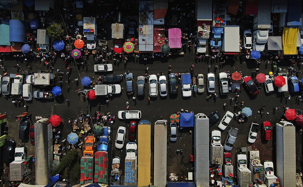Customers buy fresh fish during Holy Week at a market in Mexico City, Thursday, April 9, 2020. Catholics prepare to celebrate Holy Week amid measures to prevent the spread of the coronavirus, including stopping all religious activities across the country. (AP Photo/Fernando Llano)