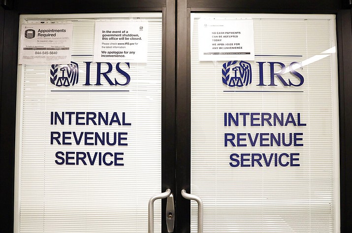 In this 2019 file photo, doors at the Internal Revenue Service (IRS) in the Henry M. Jackson Federal Building are locked and covered with blinds as a sign posted advises that the office will be closed during the partial government shutdown in Seattle. Videos and reports claiming that you'll have to pay back the relief checks the federal government is sending to millions of Americans are false, federal agencies confirmed to The Associated Press. (AP Photo/Elaine Thompson, File)