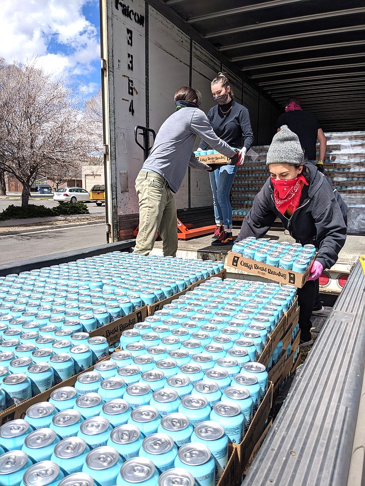 Volunteers at the Taala Hooghan Infoshop April 8 unload about 8 tons of water for relief efforts on the Navajo and Hopi reservations. (Photo courtesy of the Navajo & Hopi Families COVID - 19 Relief Fund)