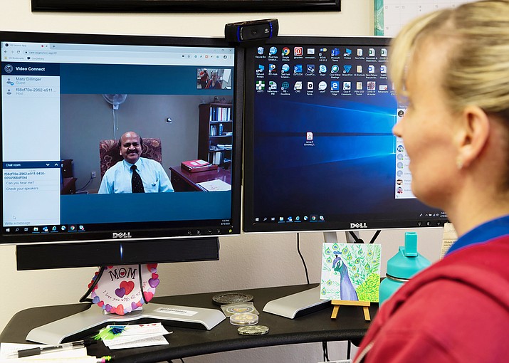 Prescott VA Public Information Officer Mary Dillinger and Chief of Staff Dr. A. Selvam demonstrate Northern Arizona Veteran Affairs Health Care System “Video Connect” video conferencing technology. (VA/Courtesy)