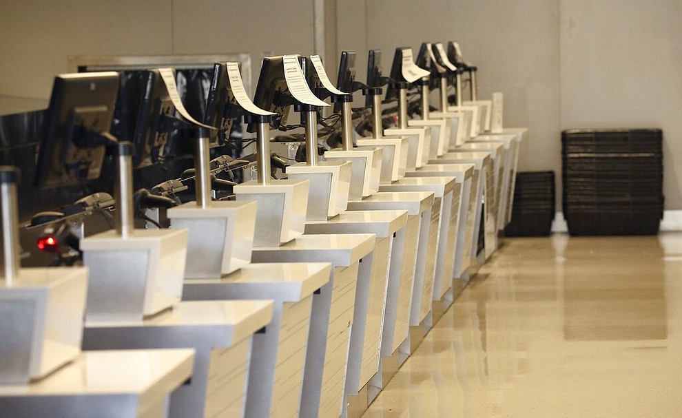 An airline check-in area is empty at Phoenix Sky Harbor International Airport on Tuesday, April 14, 2020, in Phoenix. The new coronavirus has caused a significant decrease in air travel. (AP Photo/Ross D. Franklin)