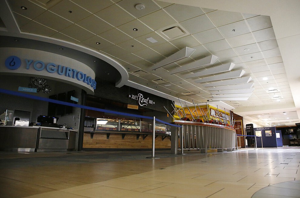 Closed restaurants are cordoned off at Phoenix Sky Harbor International Airport on Tuesday, April 14, 2020, in Phoenix. The coronavirus outbreak has caused a significant decrease in air travel. (AP Photo/Ross D. Franklin)