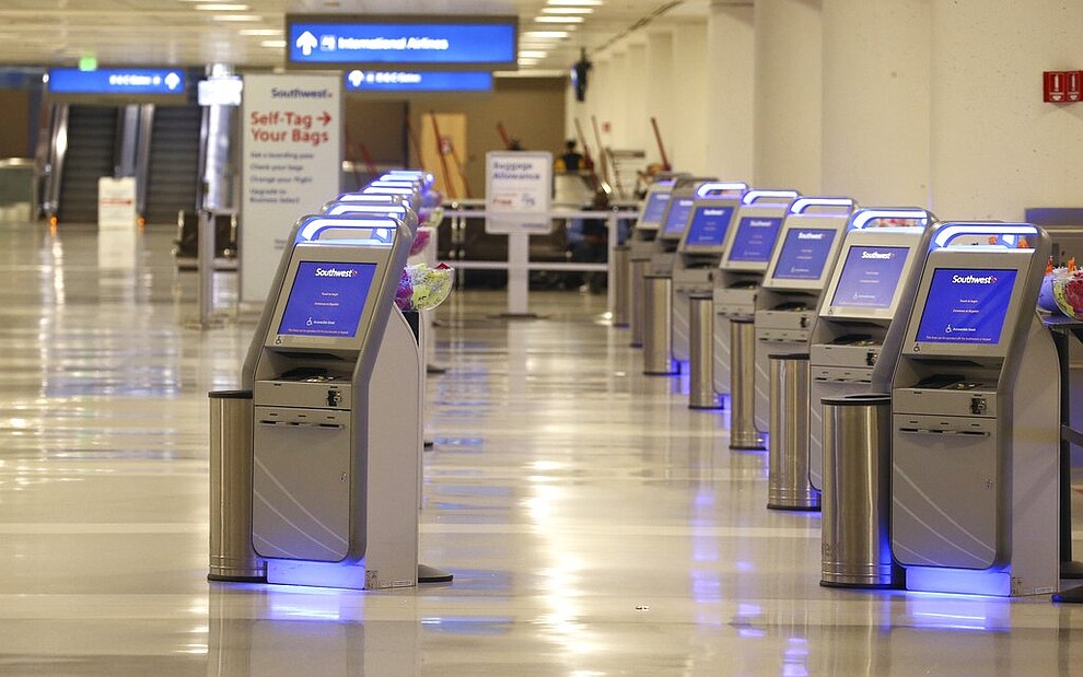 An empty Southwest Airlines check-in area is shown at Phoenix Sky Harbor International Airport Tuesday, April 14, 2020, in Phoenix. The coronavirus has caused a significant decrease in air travel. (AP Photo/Ross D. Franklin)