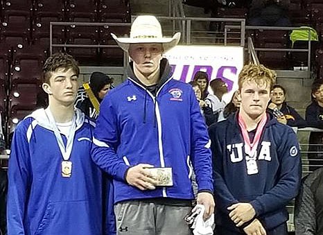 Chino Valley wrestler Keller Rock, middle, stands on the podium while holding the buckle trophy after taking first place in the Mile High Challenge on Saturday, January 4, 2020, at the Findlay Toyota Center in Prescott Valley. (Chino Valley Cougar Wrestling, Facebook/Courtesy)