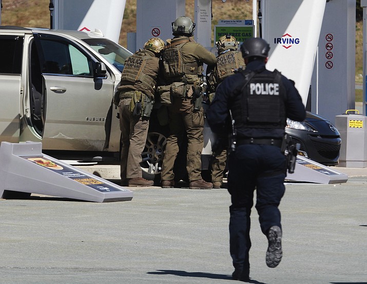 Royal Canadian Mounted Police officers surround a suspect at a gas station in Enfield, Nova Scotia on Sunday April 19, 2020. Canadian police say multiple people are dead plus the suspect after a shooting rampage across the province of Nova Scotia. It was the deadliest shooting in Canada in 30 years. (Tim Krochak/The Canadian Press via AP)