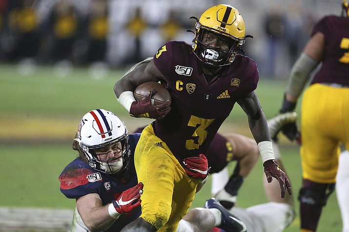 In this Nov. 30, 2019, file photo, Arizona State's Eno Benjamin (3) slips the tackle of Arizona's Colin Schooler (7) during the second half of an NCAA college football game in Tempe, Ariz. Five NFL prospects, including Benjamin, are being featured in a Panini docu-series that chronicles their paths to the NFL. With the coronavirus outbreak, teams were not allowed to visit with prospects. These five players get to tell their stories, giving them an advantage over the rest of the field. (Darryl Webb/AP, file)