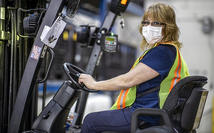This photo provided by Cindy Parkhurst. shows Cindy Parkhurst working at the Ford Flat Rock Assembly Plant in Flat Rock, Mich. Like hundreds of workers at Ford, General Motors, Toyota and other companies, Parkhurst has gone back to work to make face shields, surgical masks and even ventilators in a wartime-like effort to stem shortages of protective gear and equipment during the coronavirus pandemic.(Cindy Parkhurst via AP)