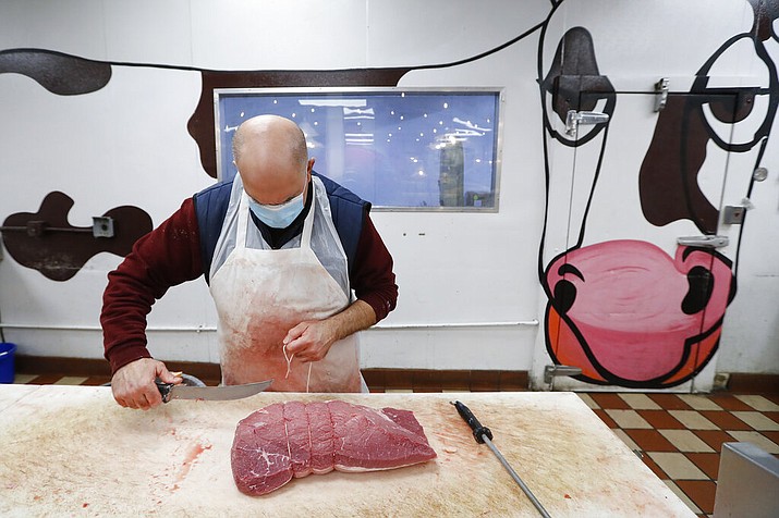 John Warminski prepares meat at Ronnie's Quality Meats in Detroit Wednesday, April 29, 2020. President Donald Trump has ordered meat processing plants to stay open amid concerns over growing coronavirus COVID-19 cases and the impact on the nation's food supply. (AP Photo/Paul Sancya)