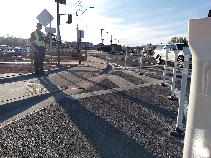 Security Officer Cameron Atkins stands on the corner of Iron Springs Road and Miller Valley Road, in front of new, flexible bollards, to help pedestrians cross safely on Thursday, April 30, 2020. (Jesse Bertel/Courier)