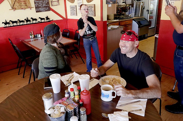 Customers smile and cheer as Debbie Thompson, owner of the Horseshoe Cafe, informs them that she is violating the state’s stay-at-home order by allowing guest dining at her restaurant Friday, May 1, 2020, in Wickenburg, Arizona. (Matt York/AP)