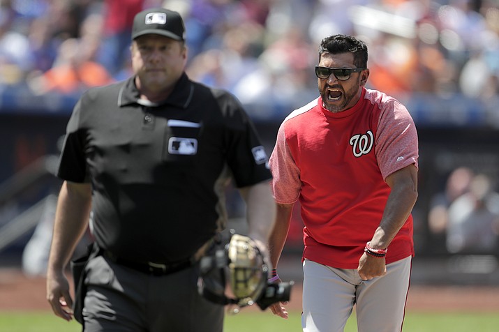In this May 23, 2019 photo, Washington Nationals manager Dave Martinez, right, reacts after being ejected by home plate umpire Bruce Dreckman for arguing after Nationals' Howie Kendrick was called out on strikes during the eighth inning against the New York Mets, in New York. Whenever baseball returns because of the coronavirus pandemic, there's an element that might come into play like never before: the sound of silence. The crack of the bat and the pop of a glove might resonate with a rich, deep echo that invokes the nostalgia of the game. But that silence also means the whispers of the past might now be clearly heard. (Julio Cortez/AP, File)