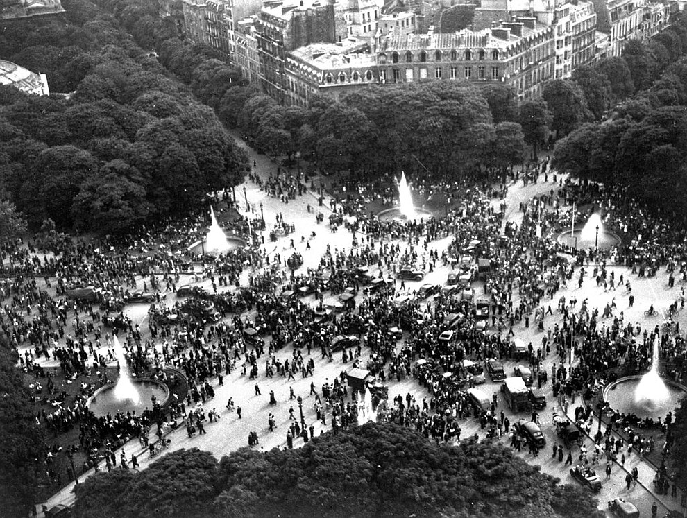 FILE - In this May 8, 1945 file photo crowds gather round the Rond-Point on the Champs-Elysees, Paris, France, on VE Day, to celebrate the announcement of Germany's unconditional surrender. On Friday's 75th anniversary of the end of World War II in Europe, talk of war is afoot again — this time against a disease that has killed at least a quarter of a million people worldwide. Instead of parades, remembrances and one last great hurrah for veterans now mostly in their nineties, it is a time of lockdown and loneliness, with memories bitter and sweet (AP Photo/Henry L. Griffin)