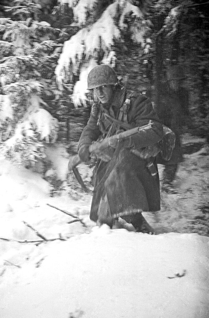 In this 1944 photo titled "Hell In Hurtgen" by photographer Tony Vaccaro, shows an American soldier in Germany's Hurtgen Forest. Vaccaro, 97, was thrown into WWII with the 83rd Infantry division which fought, like Charles Shay, in Normandy, and then came to Schmetz's doorstep for the Battle of the Bulge. On top of his military gear, he also carried a camera, and became a fashion and celebrity photographer after the war. COVID-19 caught up with him last month. Like everything bad life threw at him, he shook it off, attributing his survival to plain "fortune." (Photo courtesy Tony Vaccaro via AP)