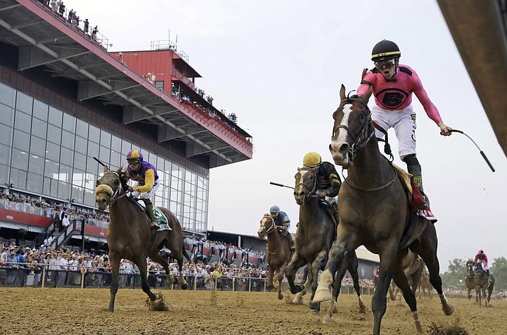 In this May 18, 2019, file photo, jockey Tyler Gaffalione, right, reacts aboard War of Will as they cross the finish line to win the Preakness Stakes horse race at Pimlico Race Course in Baltimore. The Preakness Stakes, the second leg of horse racing's Triple Crown would have been this week if not for the coronavirus pandemic. There is still no new date for the race. (Steve Helber/AP, file)