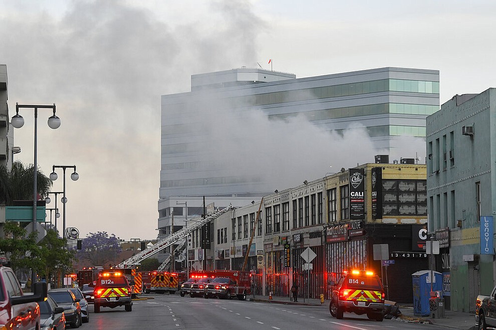 Los Angeles Fire Department firefighters work the scene of a structure fire that injured multiple firefighters, according to a fire department spokesman, Saturday, May 16, 2020, in Los Angeles. (AP Photo/Mark J. Terrill)