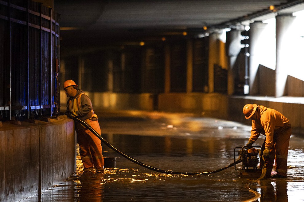 City workers remove water from Lower Wacker Drive near Randolph Street after overnight flooding, Monday, May 18, 2020 in Chicago. (Ashlee Rezin Garcia/Chicago Sun-Times via AP)