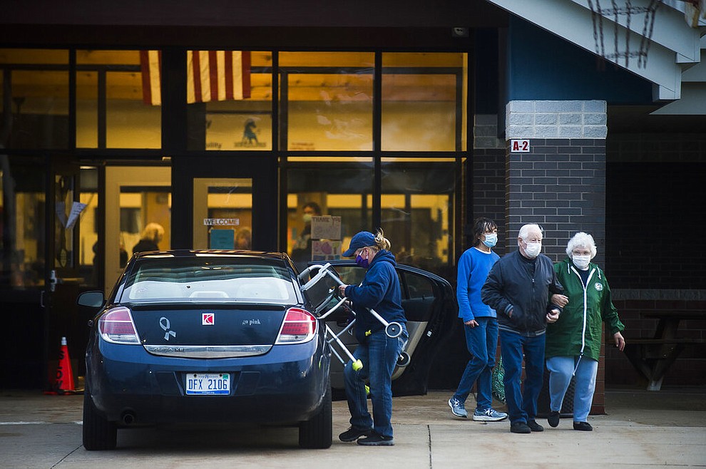 Residents of Sanford and Wixom Lakes exit a shelter at Meridian Junior High School, Tuesday, May 19, 2020 in Sanford, Mich., after spending the night following an evacuation order. People living along two mid-Michigan lakes and parts of a river have been evacuated following several days of heavy rain that produced flooding and put pressure on dams in the area. (Katy Kildee/Midland Daily News via AP)