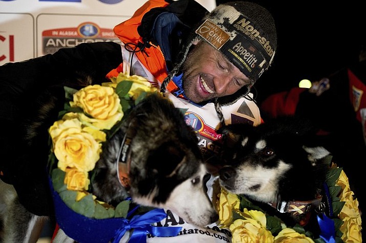 In this March 18, 2020, file photo, Thomas Waerner, of Norway, celebrates in Nome, Alaska, his win in the Iditarod Trail Sled Dog Race. Waerner is still waiting to return to his home in Norway. Waerner and his 16 dogs have been stranded in Alaska by travel restrictions and flight cancellations caused by the coronavirus pandemic. (Marc Lester/Anchorage Daily News via AP, File)