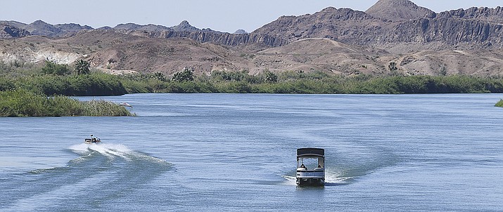 A boat heads down the Colorado River while another heads upriver May 21, 2020. A Phoenix-based company that was eyeing the Little Colorado River for power generation is floating a new proposal that would rely on groundwater rather than surface water to make electricity. (Randy Hoeft/The Yuma Sun via AP)