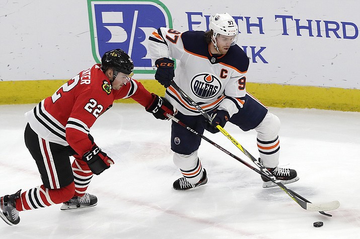 In this March 5, 2020, file photo, Edmonton Oilers center Connor McDavid, right, and Chicago Blackhawks center Ryan Carpenter vie for the puck during the first period of an NHL hockey game in Chicago. McDavid gets just his second taste of the playoffs in his fifth season. (Nam Y. Huh/AP, file)