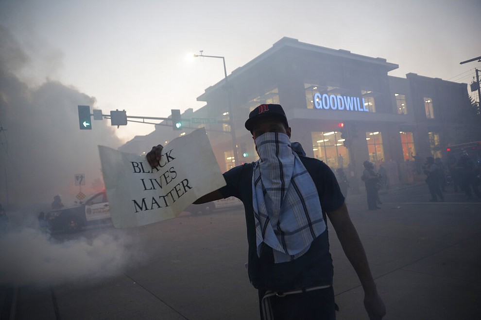 A demonstrator displays a "Black Lives Matter" sign Thursday, May 28, 2020, in St. Paul, Minn. Protests over the death of George Floyd, a black man who died in police custody, broke out in Minneapolis for a third straight night. (AP Photo/John Minchillo)