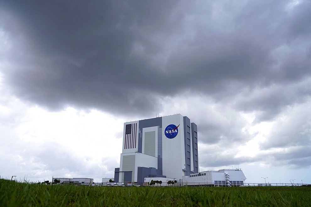 Storm clouds pass over the Vehicle Assembly Building as a SpaceX Falcon 9, with NASA astronauts Doug Hurley and Bob Behnken in the Crew Dragon capsule, sits on Launch Pad 39-A at the Kennedy Space Center in Cape Canaveral, Fla., Saturday, May 30, 2020. The two astronauts are on the SpaceX test flight to the International Space Station scheduled to liftoff Saturday. (AP Photo/David J. Phillip)