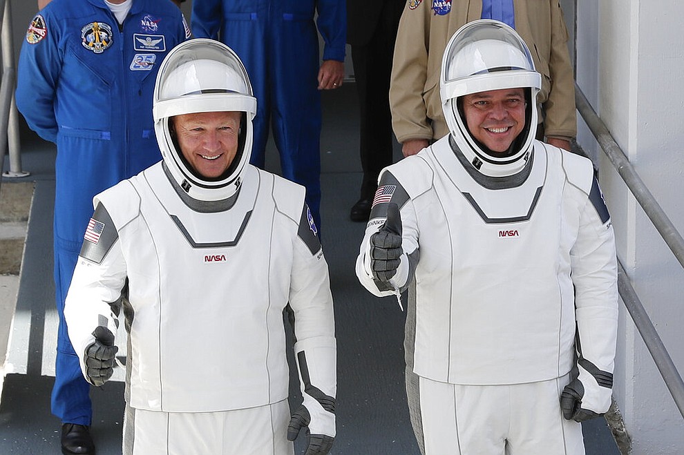 NASA astronauts Douglas Hurley, left, and Robert Behnken walk out of the Neil A. Armstrong Operations and Checkout Building on their way to Pad 39-A, at the Kennedy Space Center in Cape Canaveral, Fla., Saturday, May 30, 2020. The two astronauts will fly on a SpaceX test flight to the International Space Station. For the first time in nearly a decade, astronauts will blast into orbit aboard an American rocket from American soil, a first for a private company. (AP Photo/John Raoux)