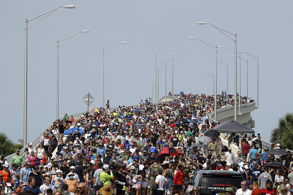 Spectators walk from their vantage point on a bridge in Titusville, Fla. after watching SpaceX Falcon 9 lift off with NASA astronauts Doug Hurley and Bob Behnken in the Dragon crew capsule, Saturday, May 30, 2020 from the Kennedy Space Center at Cape Canaveral, Fla. The two astronauts are on the SpaceX test flight to the International Space Station. For the first time in nearly a decade, astronauts blasted towards orbit aboard an American rocket from American soil, a first for a private company. (AP Photo/Charlie Riedel)